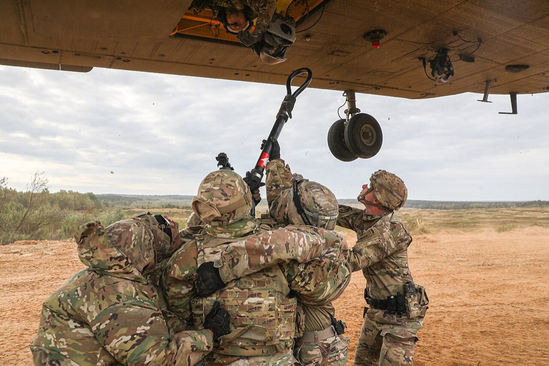 Soldiers hook a sling load beneath a CH-47 Chinook. U.S. Army photo.