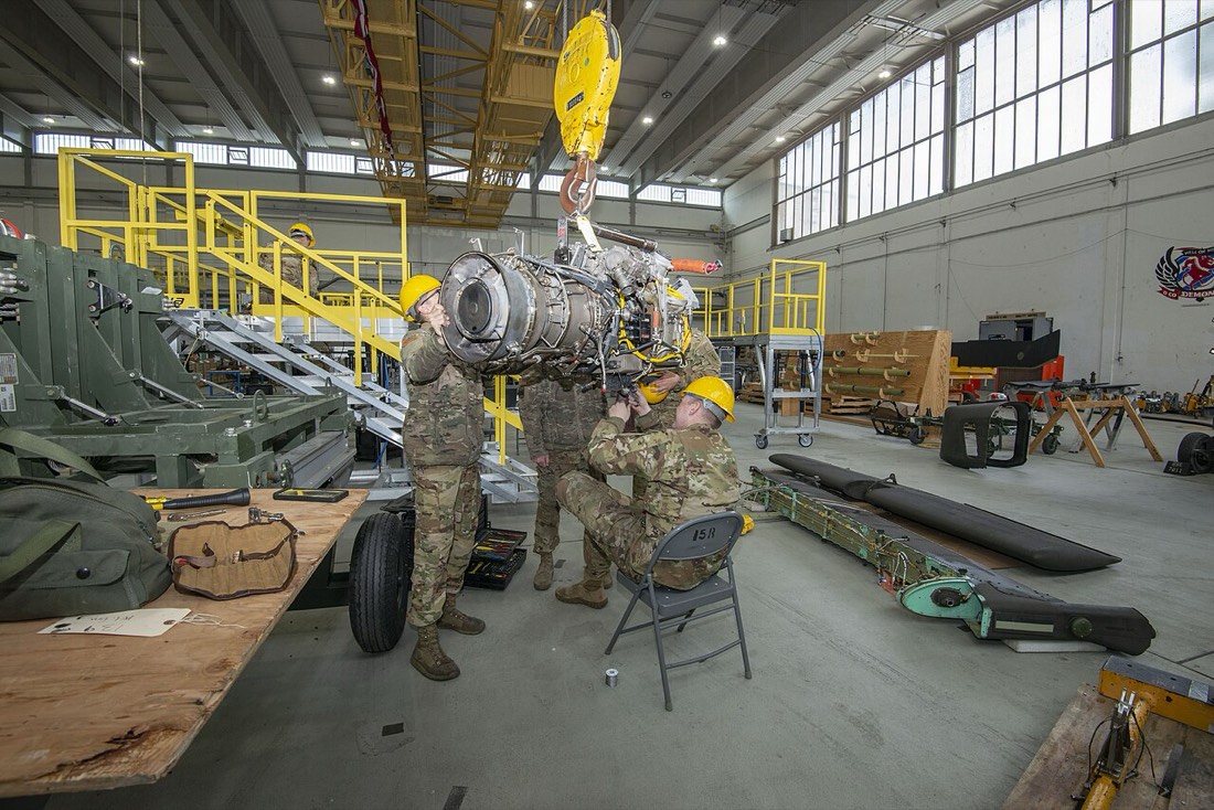 Helicopter engine on a hoist in a maintenance hangar. U.S. Army photo.